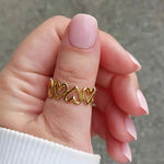 Woman wearing the Eternal Hearts gold-plated adjustable ring with delicate twin heart detail, best-selling style also offered in silver.