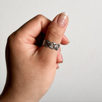 This bold silver crisscross ring adjusts to fit any finger. Hypoallergenic, waterproof, and tarnish-resistant — no more green skin, just stunning style.