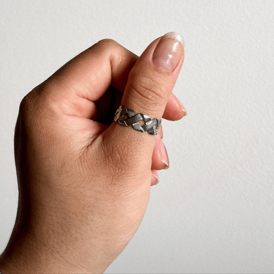 This bold silver crisscross ring adjusts to fit any finger. Hypoallergenic, waterproof, and tarnish-resistant — no more green skin, just stunning style.