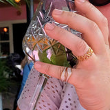 Woman wearing the Flowing Waters gold-plated adjustable ring featuring white oil-drip enamel and flowing wave style