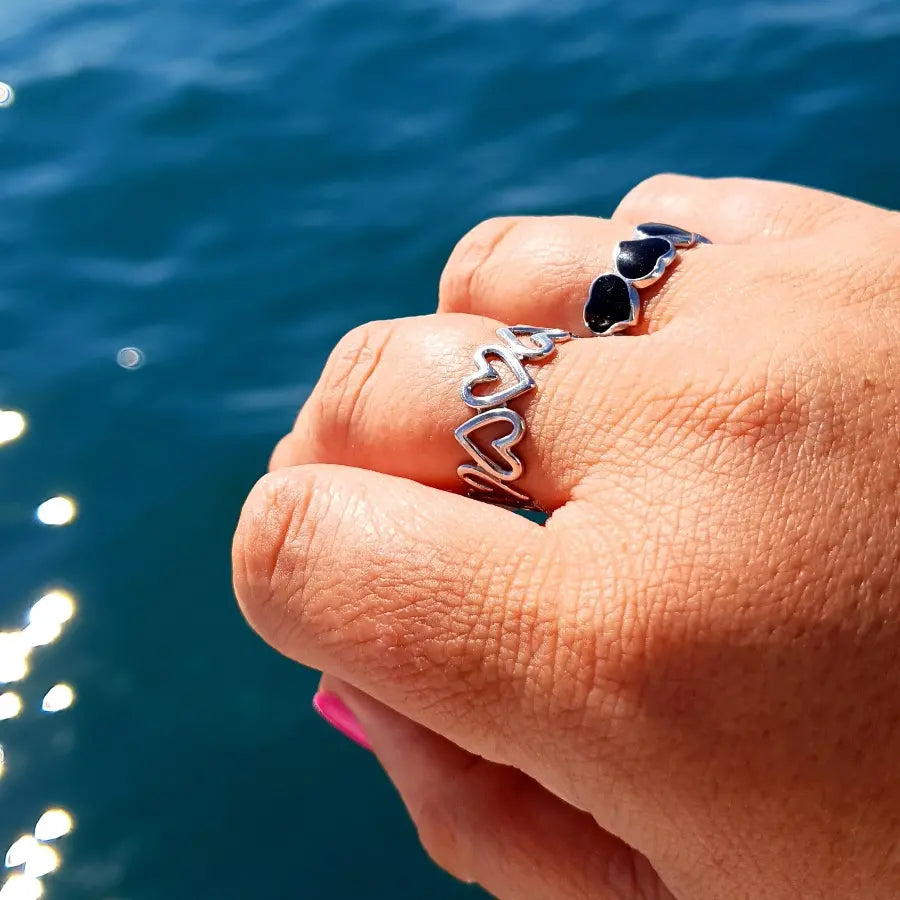 Plus-size woman’s hand in New Zealand wearing two Heart Adjustable Rings in silver, styled for a layered, playful yet elegant look.