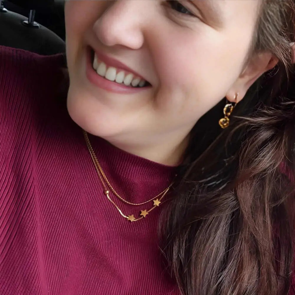 Gold 3 Wishes Necklace with three stars on a fine chain modeled by Kelsey