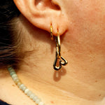 Open heart hoops in gold pictured with the prismatic huggies