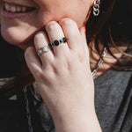 Woman wearing Harmonic Shapes and Bubbles adjustable rings in silver stainless steel, featuring sculptural curves and rounded bubble details