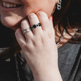 Woman wearing Harmonic Shapes and Bubbles adjustable rings in silver stainless steel, featuring sculptural curves and rounded bubble details