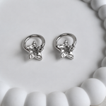 Pair of silver star-shaped earrings on a white surface