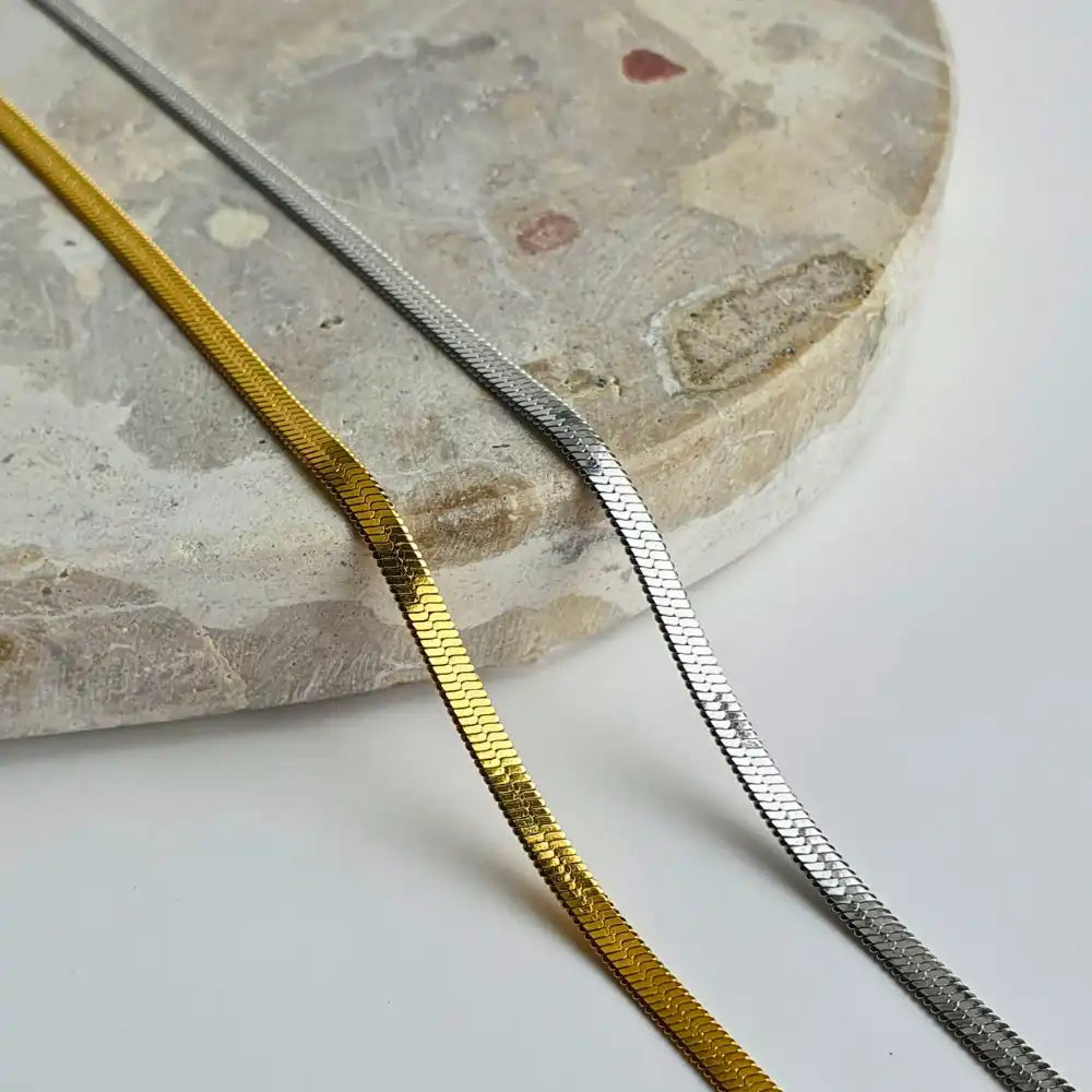 Sleek Snake Chain Necklace featuring both 18K gold-plated and classic silver options, with a stunning herringbone design. Available in 45cm+5cm and 60cm+5cm lengths. Waterproof, hypoallergenic, and tarnish-resistant.
