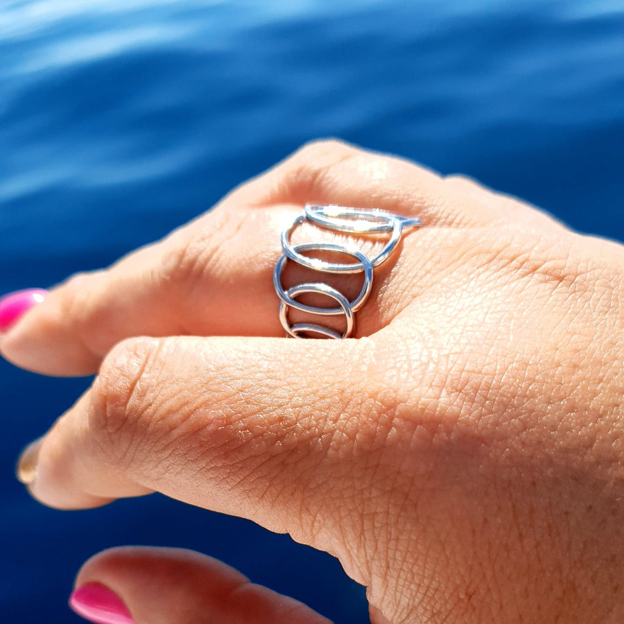 Twisted Ovals Adjustable Ring - Silver on plus size hand above the ocean