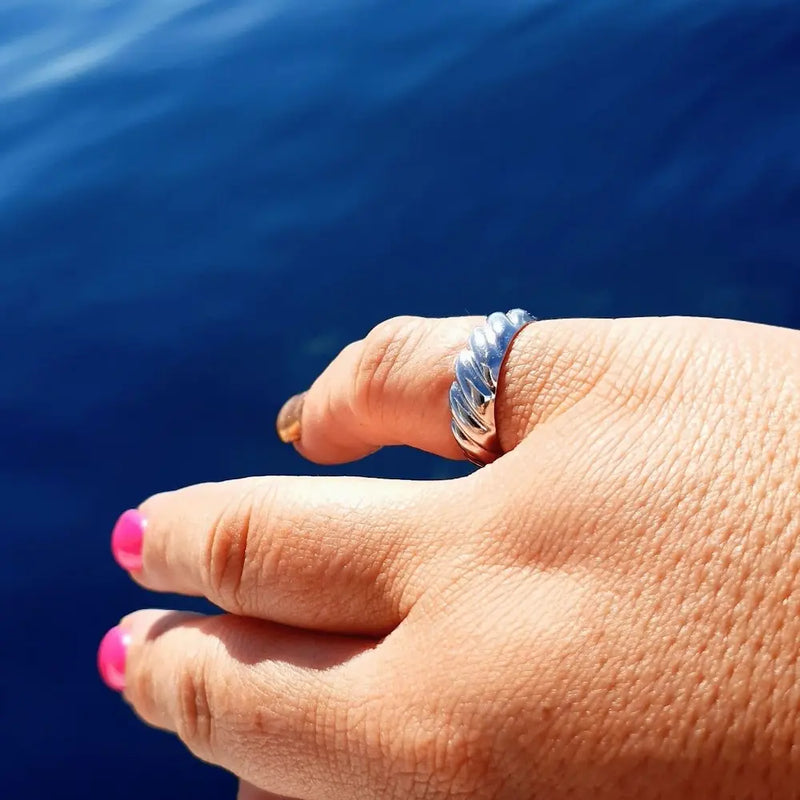 Plus-size woman wearing a silver open ring, standing by the ocean. A powerful, size-inclusive moment showcasing jewellery that fits and empowers every body.