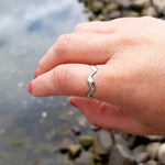 Plus-size woman’s hand wearing the Elegant Waves Ring in silver, showcasing a flowing, wave-inspired design with a polished finish.