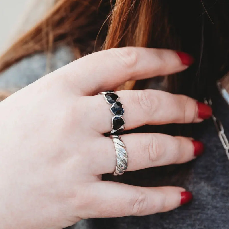 Silver Eternal Hearts ring with black enamel twin heart design paired with Crescent Elegance open ring, both worn by a woman for a contemporary stacked ring style