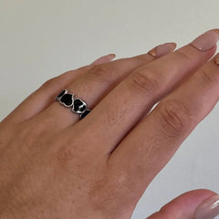 Woman wearing the Eternal Hearts adjustable ring in silver with black enamel accents and dual heart design