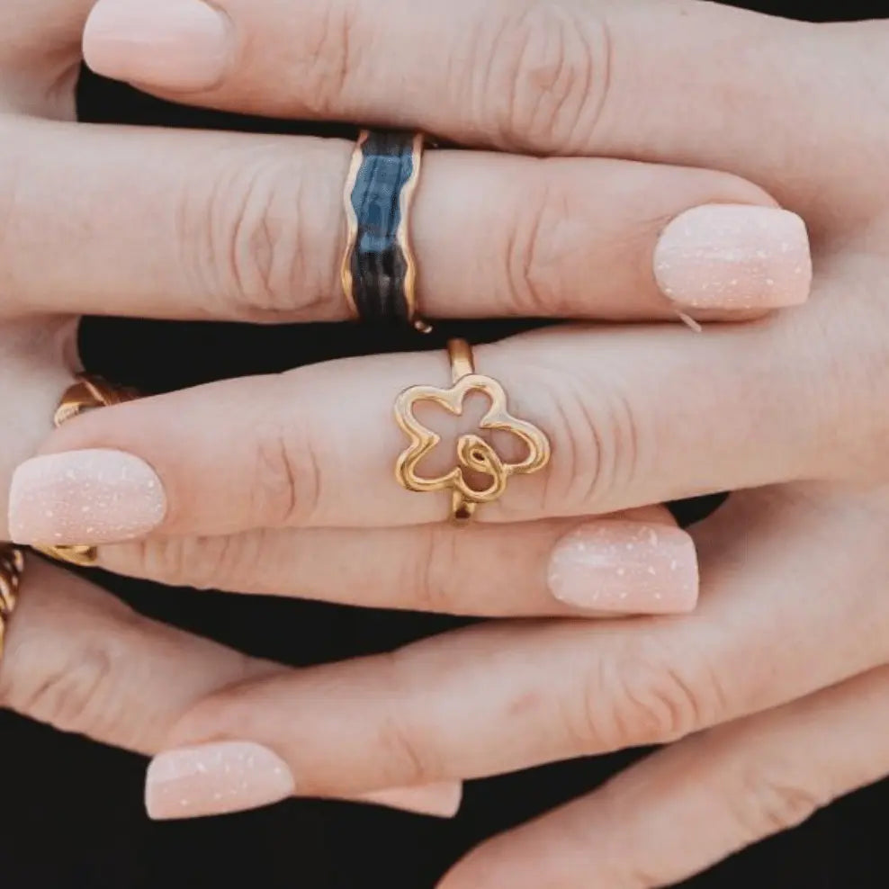 Plus-size woman’s hand wearing the Flower Power Adjustable Ring in 18k gold plating, featuring a cute floral design with sculpted petal details.