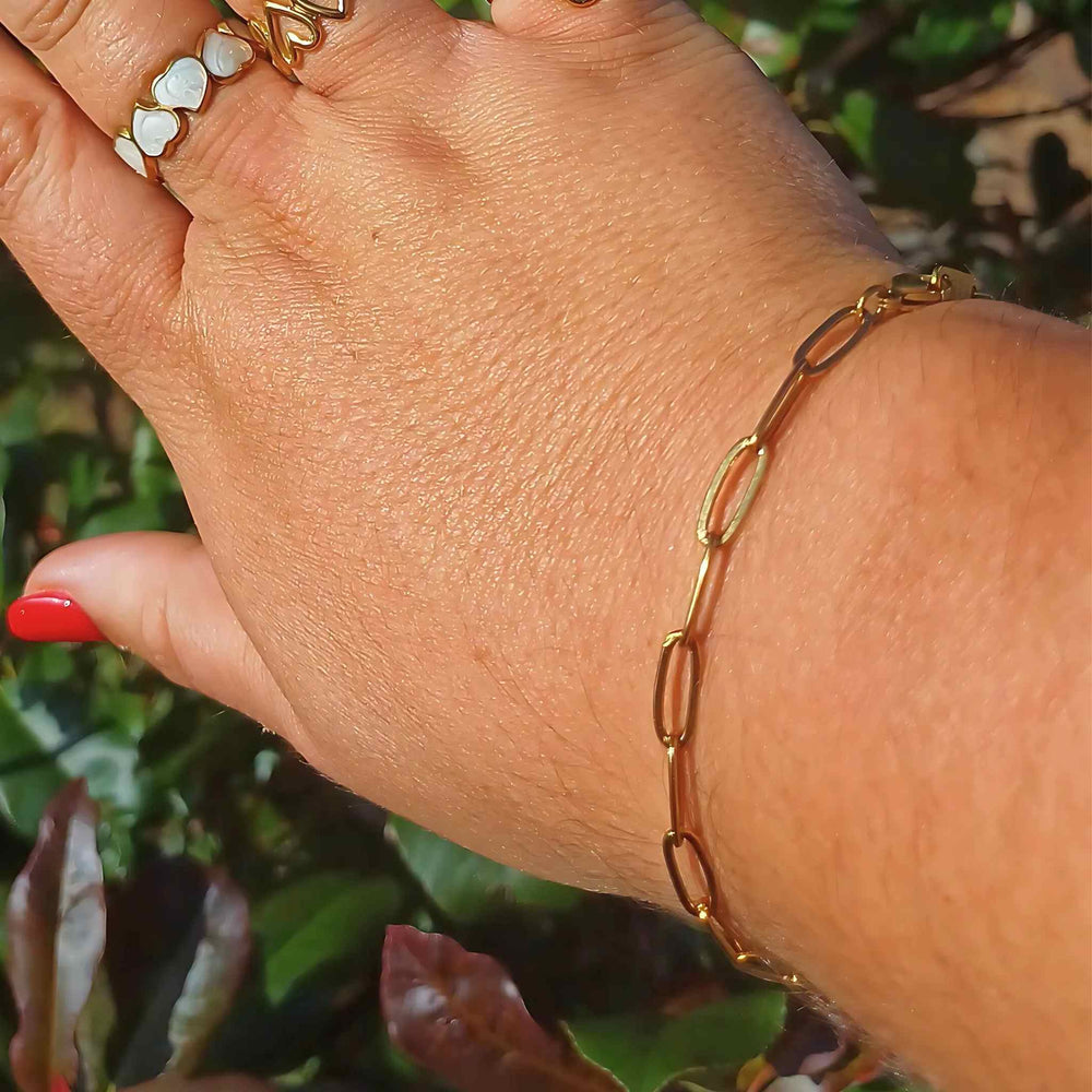 Plus-sized woman wearing a minimalist gold-plated paperclip bracelet with elongated links, adjustable fit, also comes in silver