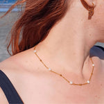 Standard-size woman wearing the 40cm Ocean Whispers Freshwater Pearl Necklace with 18K gold-plated chain and natural freshwater pearls, styled beautifully on the beach.