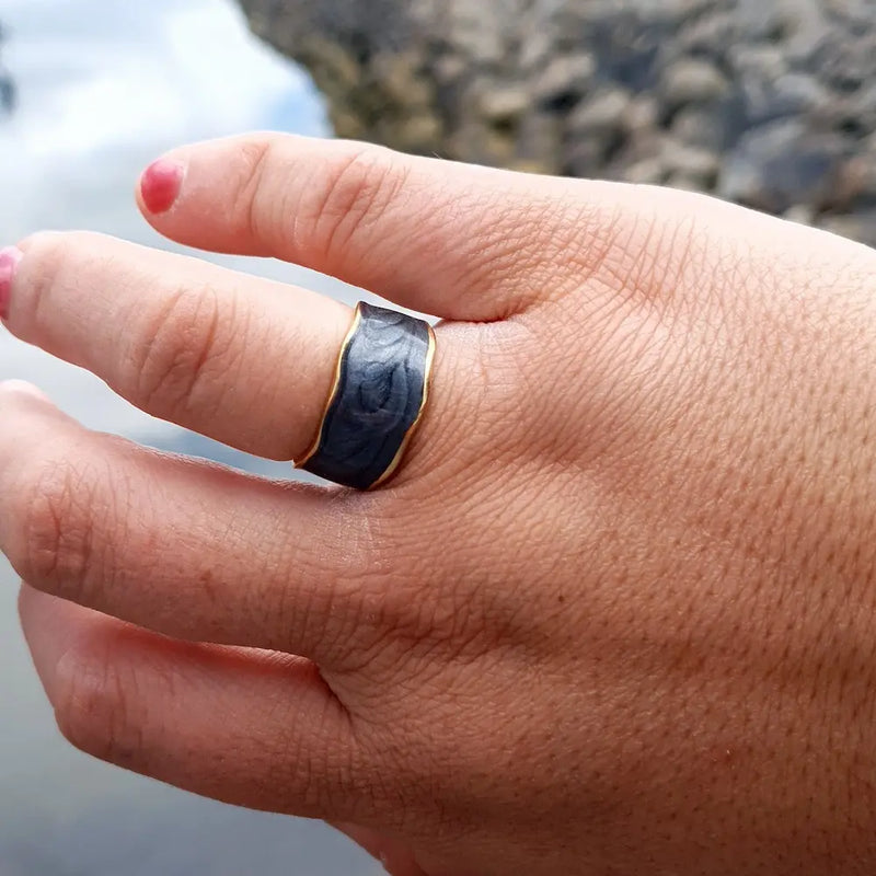 Plus-size woman’s hand wearing the Timeless Elegance Open Ring in 18k gold plating with a black enamel accent, showcasing a modern, minimalist design.