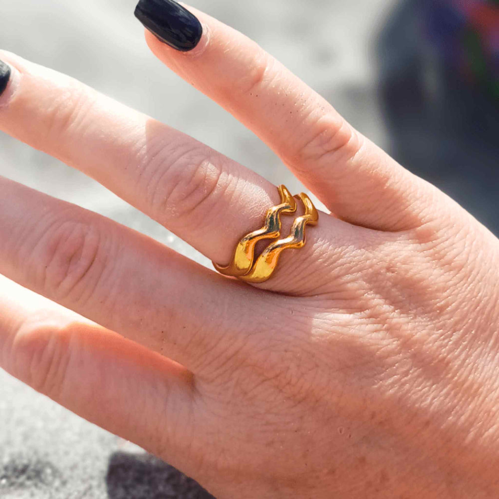 Double-stacked Elegant Waves gold-plated adjustable rings worn by a woman, featuring a sculptural, wave-inspired design